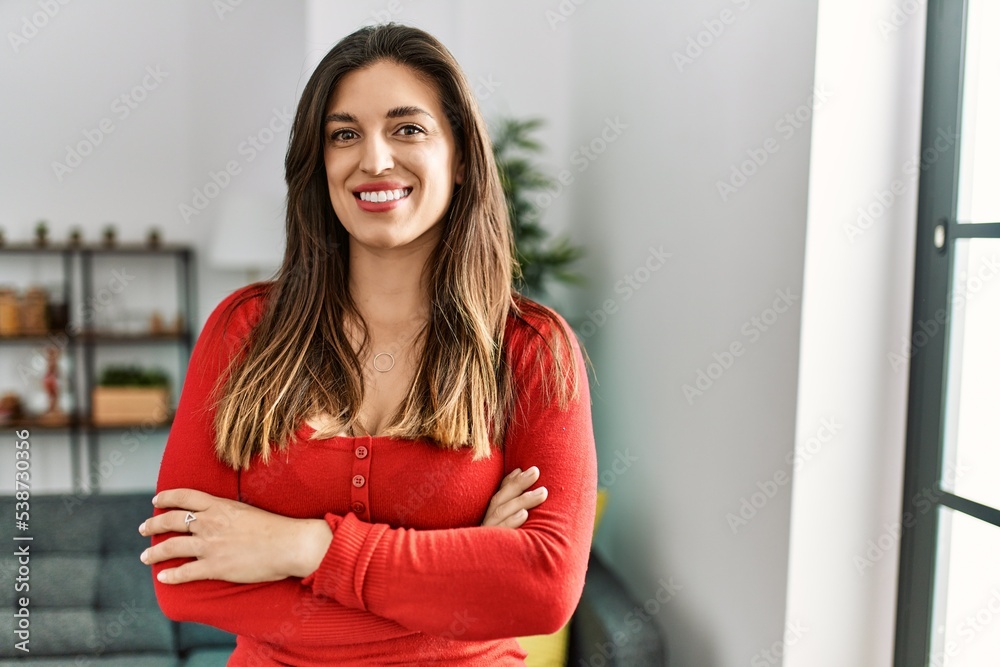 Young woman smiling confident with arms crossed gesture at home