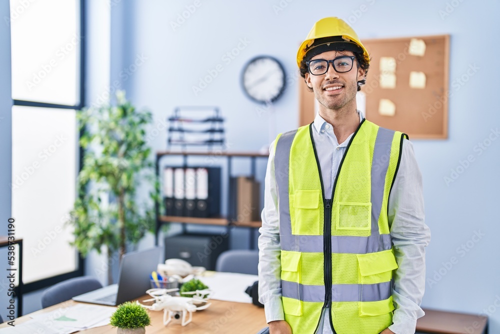 Hispanic man wearing architect hardhat with a happy and cool smile on face. lucky person. Hispanic man wearing architect hardhat with a happy and cool smile on face. lucky person.