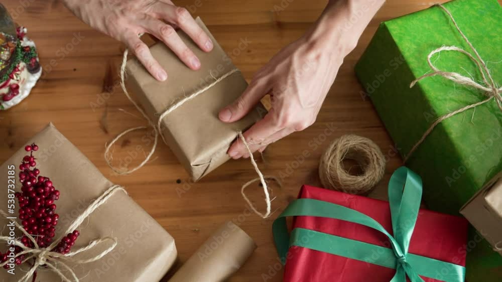 Man wrapping Christmas gift with twine. Christmas or New year DIY packing Concept. 