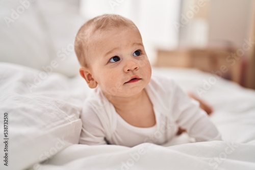 Adorable toddler crawling on bed at bedroom