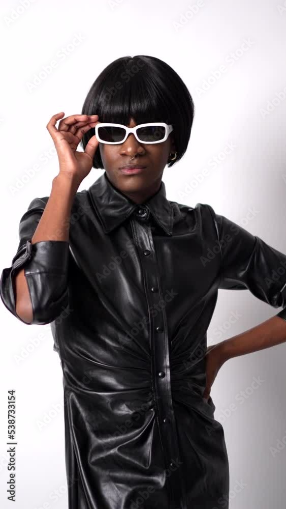 Black ethnic man in studio with white background, LGTBI concept, wearing leather and sunglasses