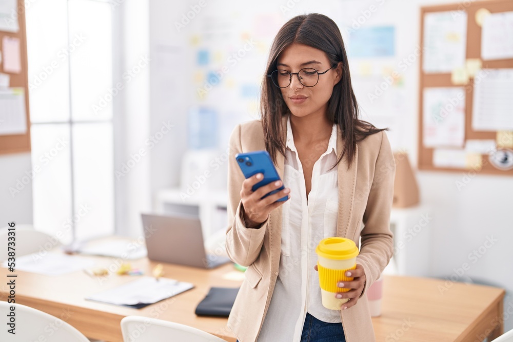 Young beautiful hispanic woman business worker using smartphone drinking coffee at office Young beautiful hispanic woman business worker using smartphone drinking coffee at office