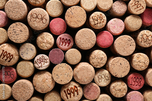 Many wine corks with different dates as background, top view