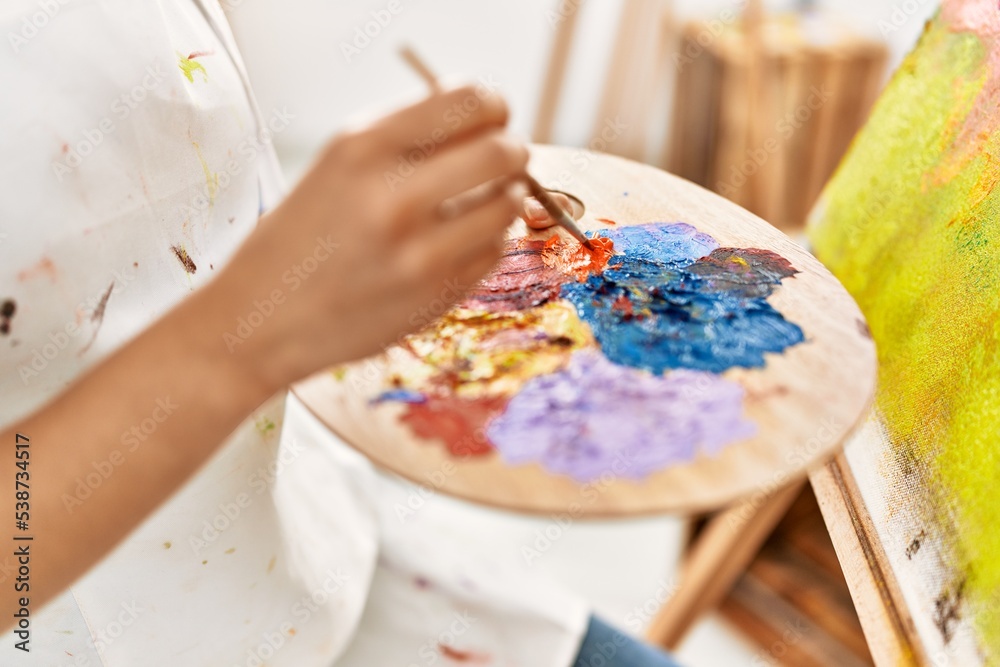Young latin woman mixing color on palette at art studio Young latin woman mixing color on palette at art studio