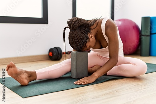 Young african american woman stretching at sport center