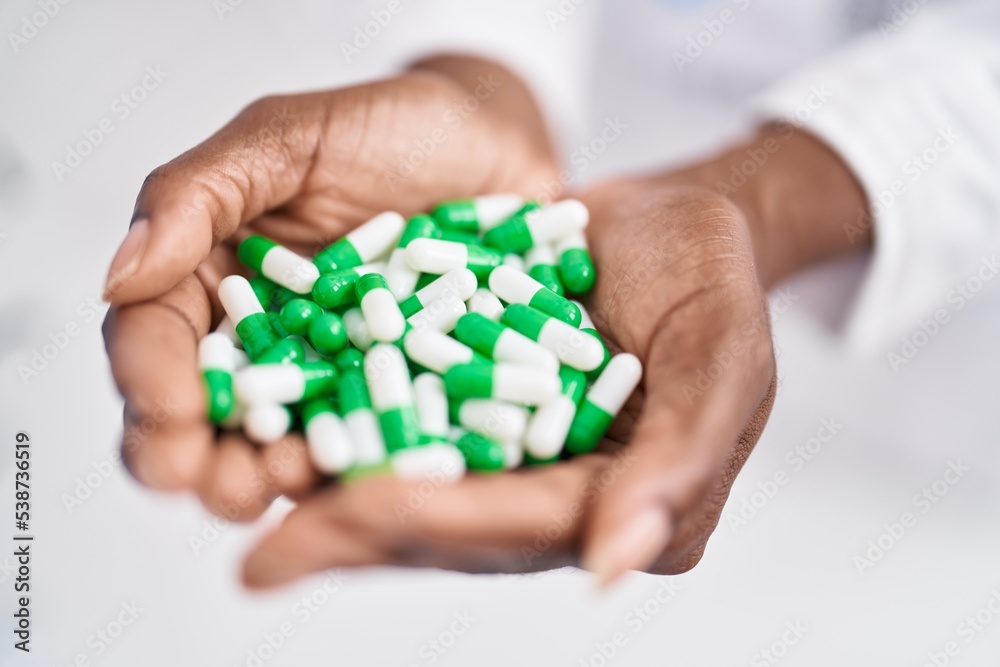 African american woman pharmacist holding pills at pharmacy African american woman pharmacist holding pills at pharmacy