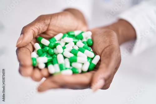 African american woman pharmacist holding pills at pharmacy