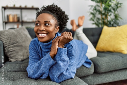 African american woman smiling confident lying on sofa at home