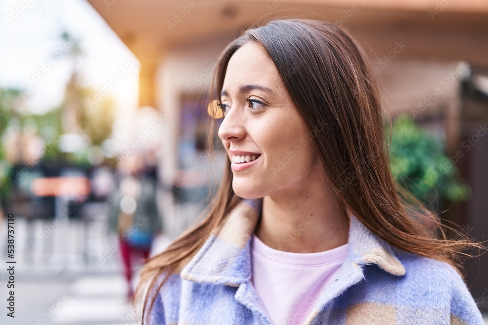 Young beautiful hispanic woman smiling confident looking to the side at street