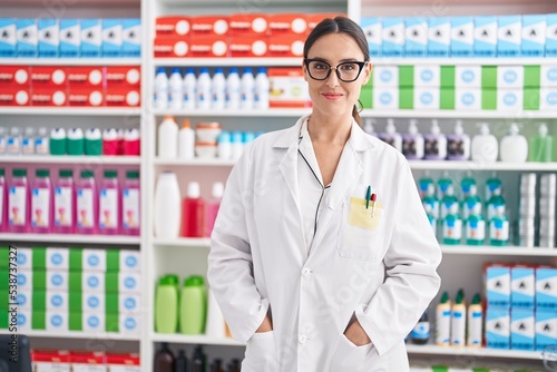 Young beautiful hispanic woman pharmacist smiling confident standing at pharmacy