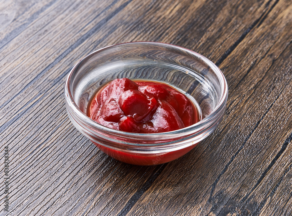 Bowl of tomato sauce on wooden surface Bowl of tomato sauce on wooden surface