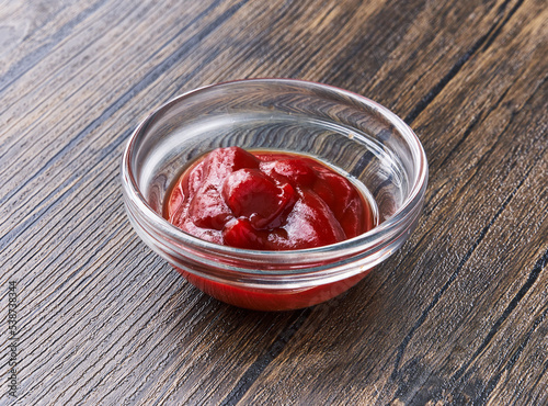  Bowl of tomato sauce on wooden surface