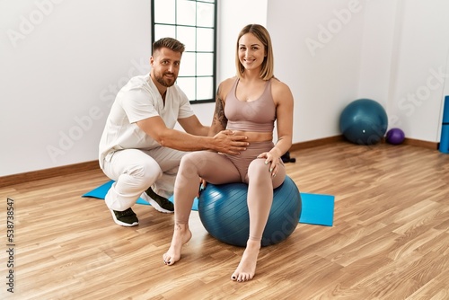 Physioterapist man giving rehab treatment to woman at the clinic.