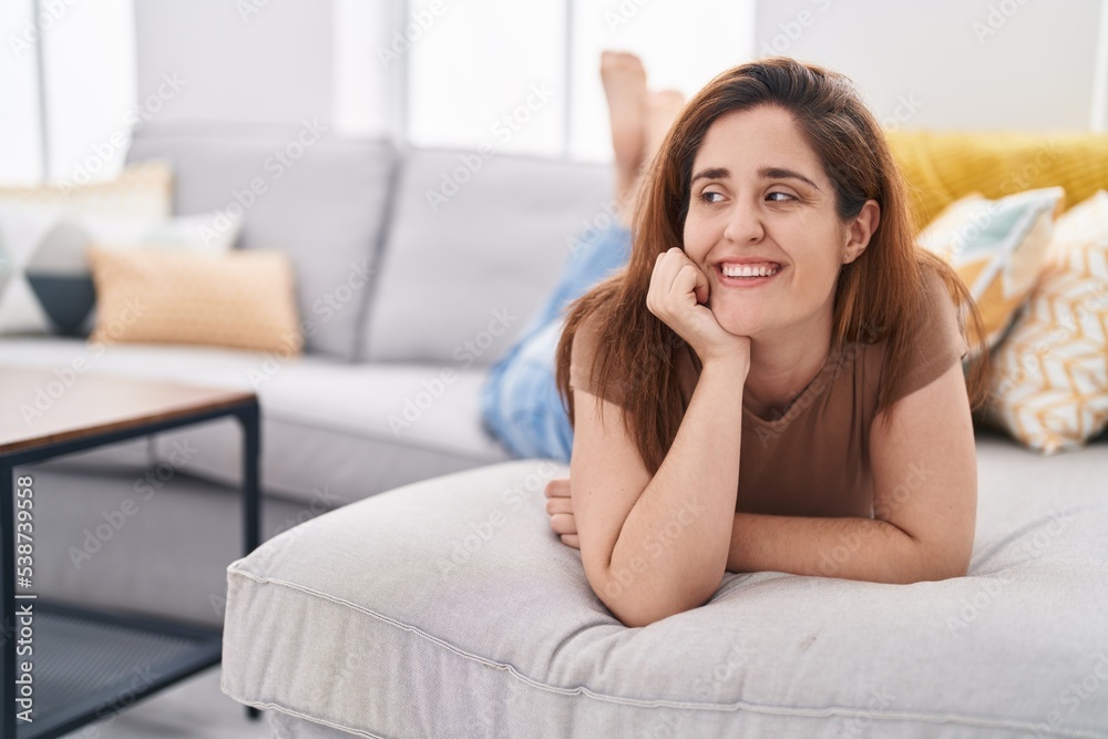 Young woman smiling confident lying on sofa at home Young woman smiling confident lying on sofa at home