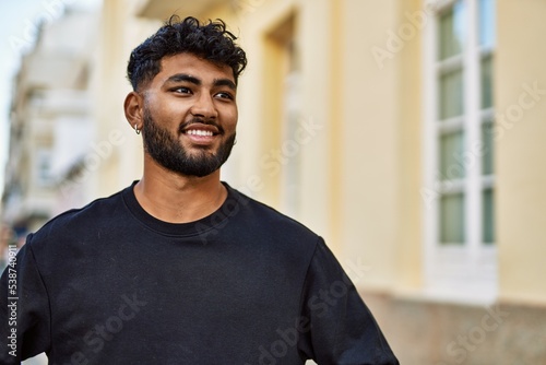 Young arab man smiling confident at street