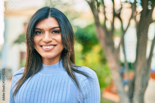 Beautiful hispanic woman smiling confient at the park photo