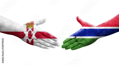 Handshake between Gambia and Northern Ireland flags painted on hands, isolated transparent image. photo