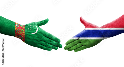 Handshake between Gambia and Turkmenistan flags painted on hands, isolated transparent image.
