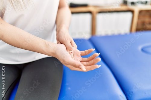 Young chinese woman with pain on hand at clinic