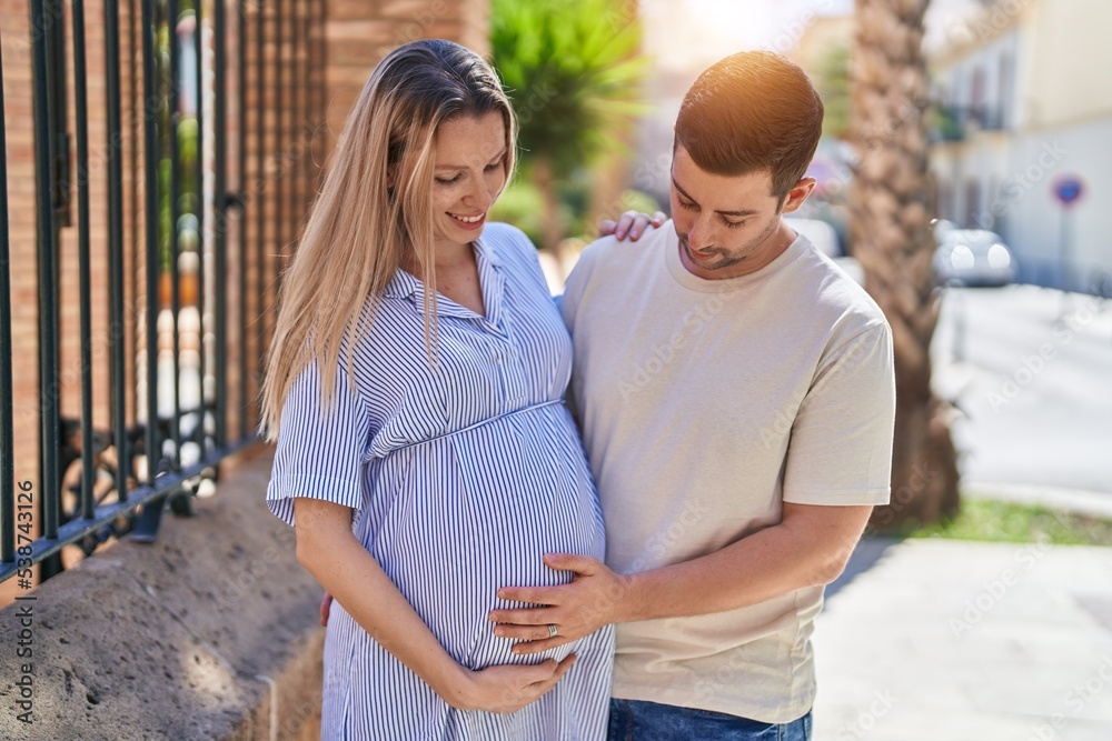 Man and woman couple hugging each other expecting baby at street Man and woman couple hugging each other expecting baby at street