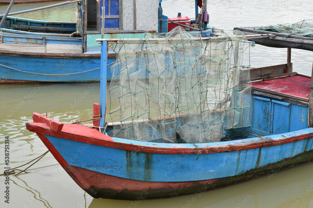 Blue old fishing ship with nets for catching crabs.