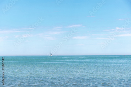 Sailing boat in open water seeing from a distance on a sunny day
