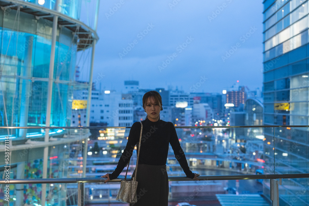 Fototapeta premium イルミネーションのあるビルにいる女性