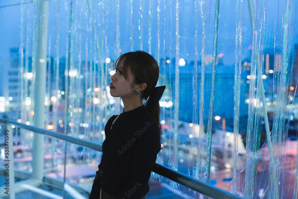 Fototapeta premium イルミネーションのあるビルの中で待ち合わせをする女性
