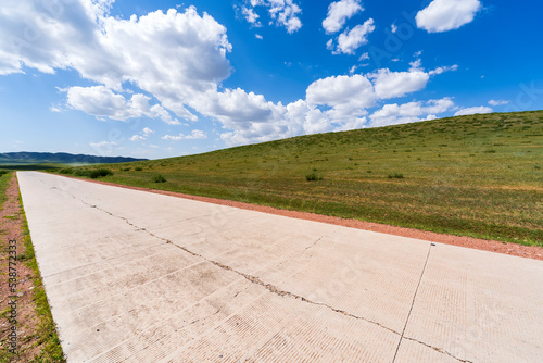 Fotografie The tarmac road is under blue sky and white clouds