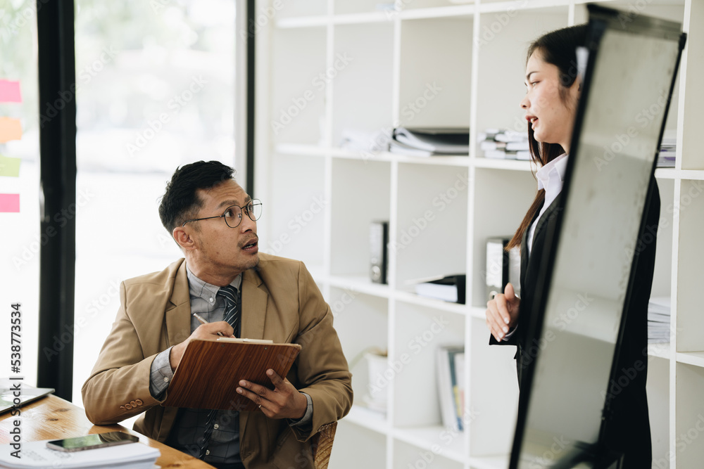 Group of Asian businessman and office workers working in team conference with project planning document on meeting table. Group of Asian businessman and office workers working in team conference with project planning document on meeting table.