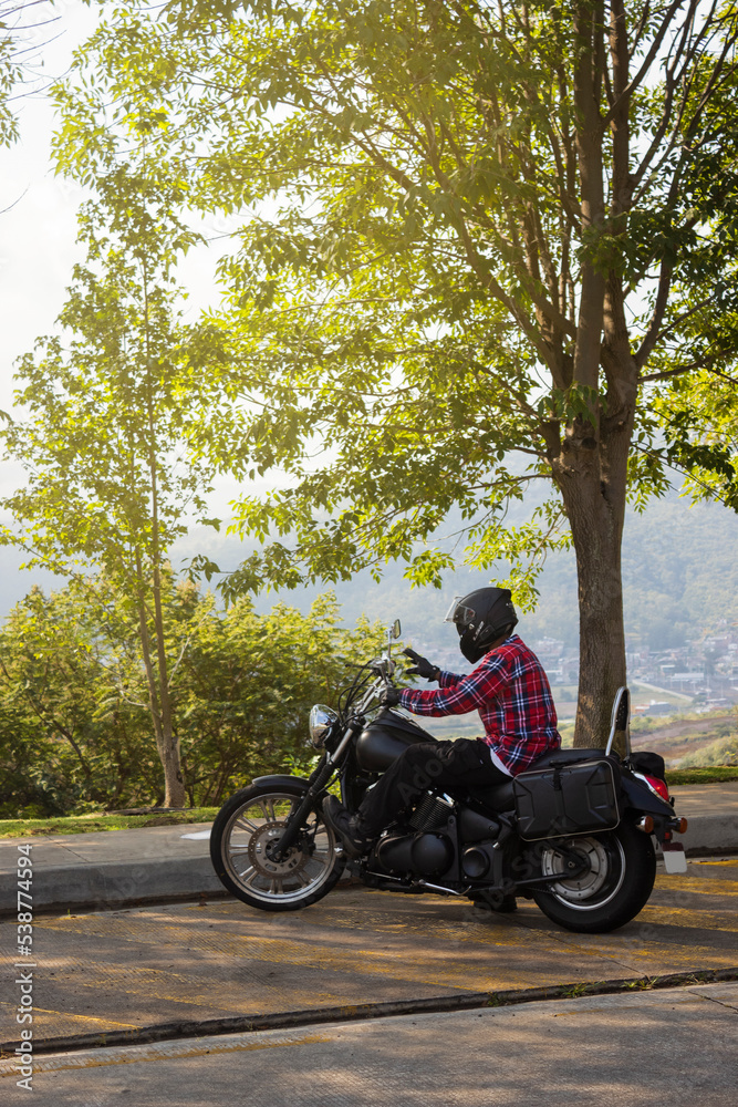 Person riding a motorcyle with a landscape behind Person riding a motorcyle with a landscape behind
