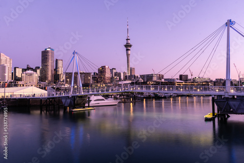 Obraz na płótnie Auckland, New Zealand September 20 2021: The sun sets over the Viaduct marina and Auckland business district skyscrapers in New Zealand largest city w salonie