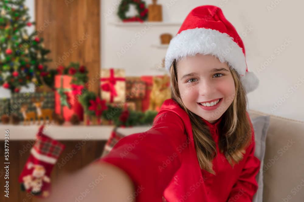 A child using a smartphone to take a selfie herself at a Christmas's Eve party A child using a smartphone to take a selfie herself at a Christmas's Eve party