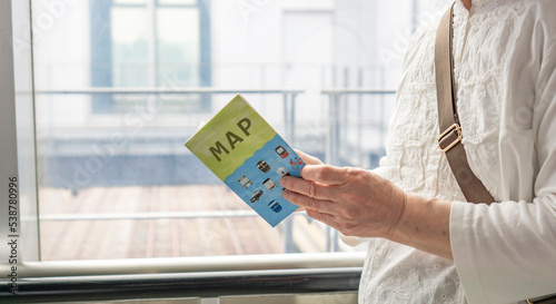 A senior woman looking at map at station. 駅で地図をみるシニア女性