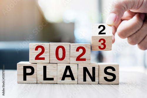 hand flipping block 2022 to 2023 PLAN text on table. Resolution, strategy, goal, motivation, reboot, business and New Year holiday concepts