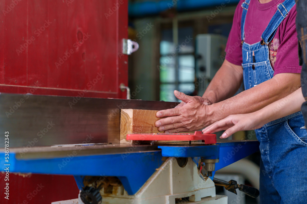 Tutor With Male Carpentry Student In Workshop Studying For Apprenticeship At College Using Bench Saw Tutor With Male Carpentry Student In Workshop Studying For Apprenticeship At College Using Bench Saw