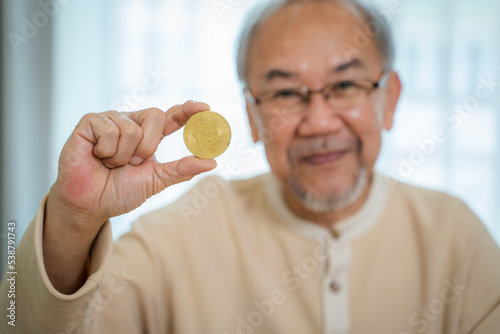 Senior man holding in hand symbol of crypto currency,Electronic virtual money for web banking and international network payment.