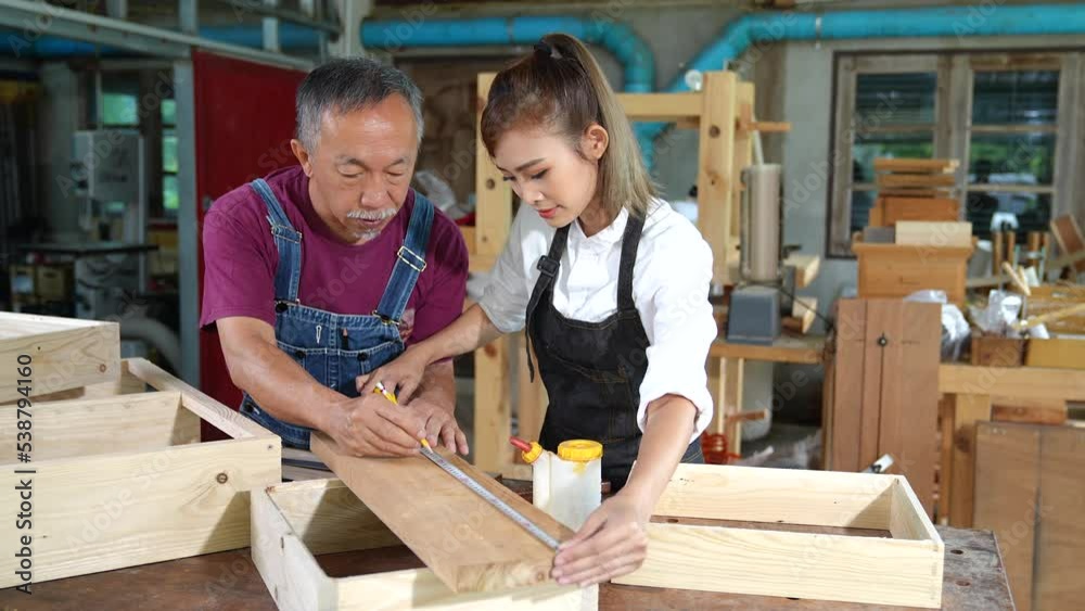 Tutor With Female Carpentry Student In Workshop Studying For Apprenticeship At College ,Teacher explaining a structure students while standing in a woodwork class Tutor With Female Carpentry Student In Workshop Studying For Apprenticeship At College ,Teacher explaining a structure students while standing in a woodwork class