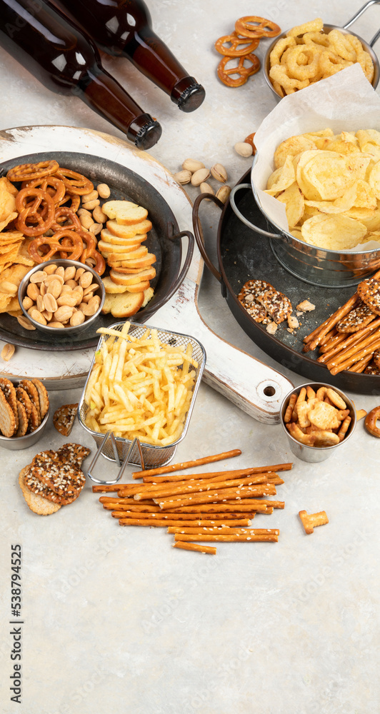 Fototapeta premium Assortment of beer and salty snacks on light background.