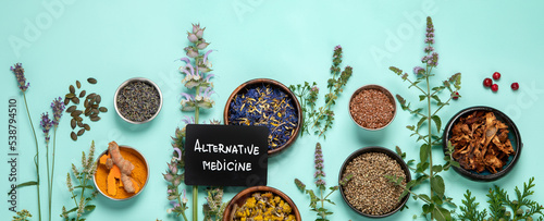 Fotografie Alternative herbal medicine on green background.