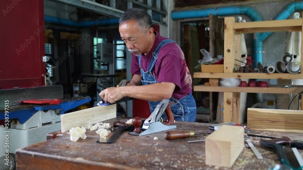 Carpenter hands working with a chisel and hammer on wooden workbench Carpenter hands working with a chisel and hammer on wooden workbench