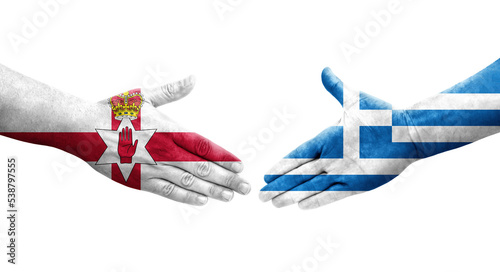 Handshake between Greece and Northern Ireland flags painted on hands, isolated transparent image. photo