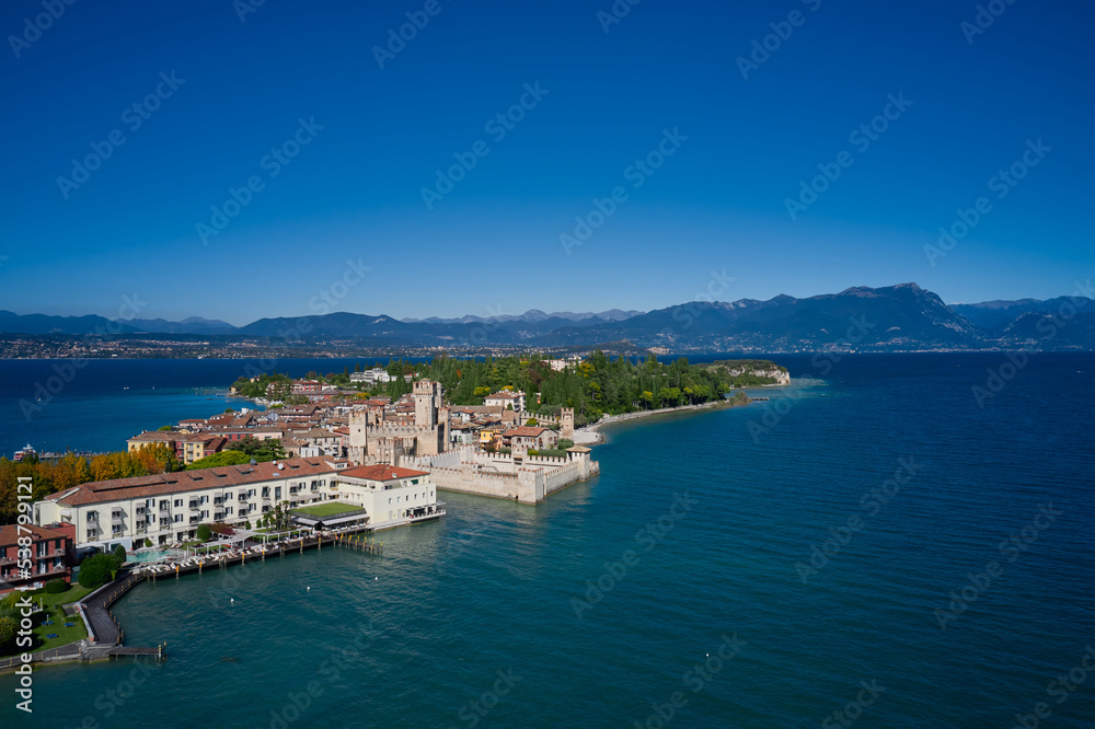 Top view of the town of Sirmione, Italy. Lake Garda, a tourist destination in northern Italy. Autumn in Italy on Lake Garda, Sirmione peninsula. Trees in the autumn season.