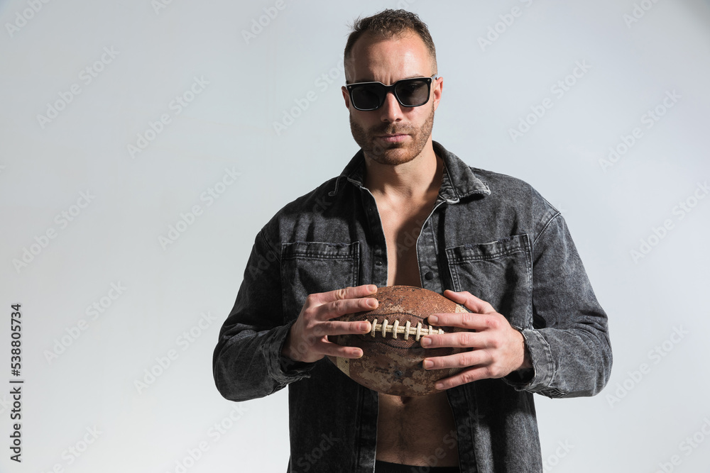 sexy player holding rugby ball and posing in a cool way sexy player holding rugby ball and posing in a cool way