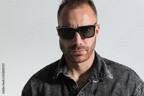 sexy unshaved guy wearing sunglasses and posing