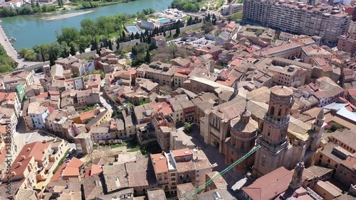 Scenic aerial view of medieval Roman Catholic Cathedral of Saint Mary surrounded by residential buildings with terracotta tiled roofs in historical center of Tudela on sunny spring day, Spain. High photo