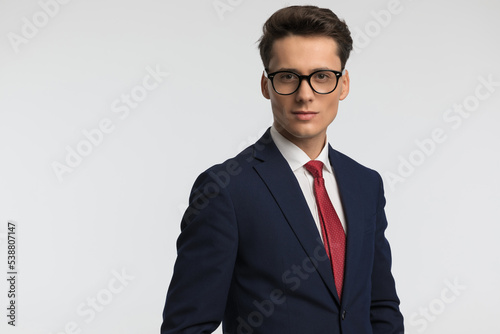 handsome elegant man in navy blue suit with red tie wearing glasses