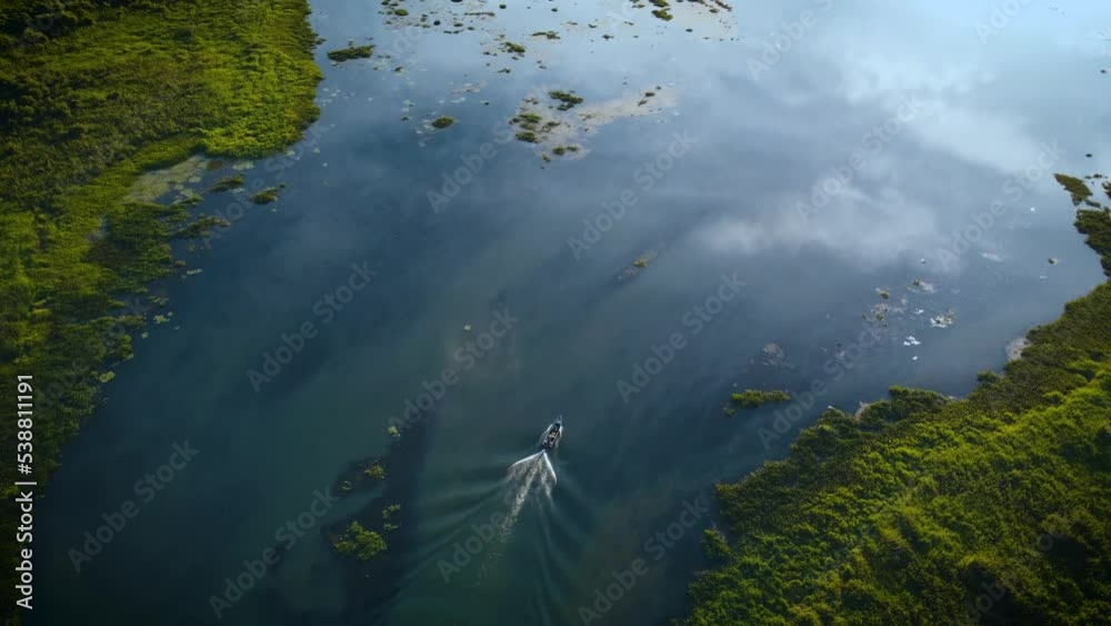 aerial view of a speed boat on the river Parana with the sky mirrored in the river aerial view of a speed boat on the river Parana with the sky mirrored in the river