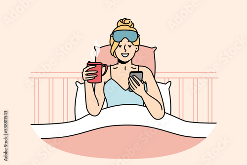 Girl who just woke up sits in bed, looks through news, messages on smartphone, drinks coffee. Awakened woman chats in social networks on cell phone, holds cup of hot tea. Vector isolated illustration.