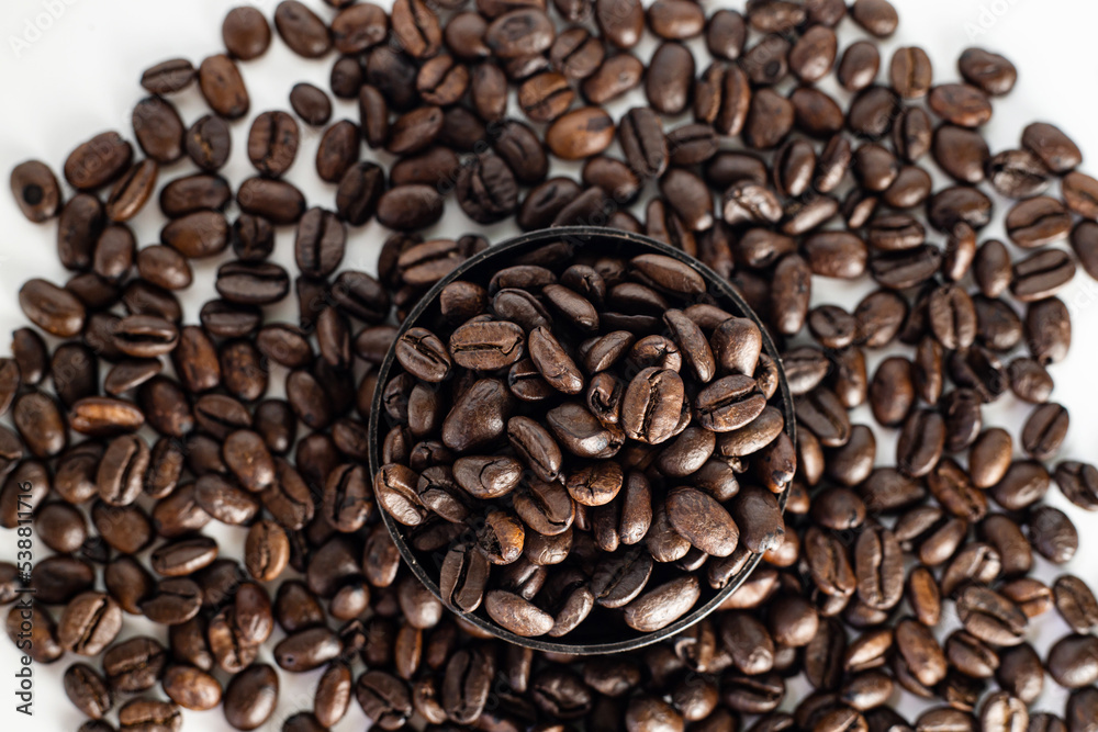 Coffee Beans on white background. close up. Coffee grounds. Freshly roasted coffee beans. Image of a drink made from granules, derived from coffee plant. Copy space for text.